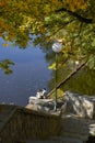 Romantic young couple sitting by the water looking at the  autumn landscape. Royalty Free Stock Photo