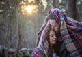 Romantic young couple snuggle under a blanket in the New England woods Royalty Free Stock Photo