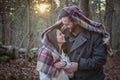 Romantic young couple under a blanket in the forest