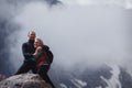 Romantic young happy couple kissing and hugging. rain and fog. Young couple in love on the background of mountains Royalty Free Stock Photo