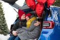 Romantic young hipster couple hugging while sitting in car trunk. Love, valentines and holiday concept. Kiss and hug Royalty Free Stock Photo