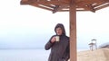 Romantic young man relaxing on the beach with , drinking hot tea or coffee from thermos. Calm and cozy evening. Royalty Free Stock Photo