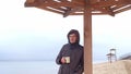 Romantic young man relaxing on the beach with , drinking hot tea or coffee from thermos. Calm and cozy evening. Royalty Free Stock Photo