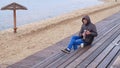 Romantic young man relaxing on the beach with , drinking hot tea or coffee from thermos. Calm and cozy evening. Royalty Free Stock Photo