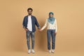 Romantic Young Muslim Couple Holding Hands While Standing Together Over Beige Background Royalty Free Stock Photo