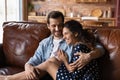 Romantic young spouses relaxing cuddling on comfortable sofa at home