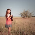 Romantic young woman in hat standing on meadow in hot summer day Royalty Free Stock Photo