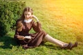 Romantic young woman reading a book in the garden sitting on the grass. Relax outdoor time concept. Royalty Free Stock Photo