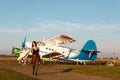 Romantic young woman ready for traveling. Standing near the ancient airplane waiting for departure Royalty Free Stock Photo