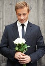 Romanticizing. Portrait of a handsome man holding a bunch of white roses and smiling. Royalty Free Stock Photo