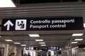 A bilingual airport sign indicating the direction of the passport control