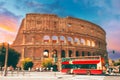 Rome, Italy. Amazing Scenic View Colorful Sky Above Colosseum. Red Hop On Hop Off Touristic Bus For Sightseeing In Royalty Free Stock Photo