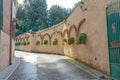 Narrow curving lane with potted plants on wall