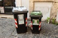 Rome, Italy - April 07, 2022, some public garbage buckets along the sidewalk of an urban street. Two Trash cans of mixed