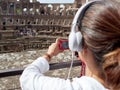 Tourist women listen the audioguide while visiting the Colosseum
