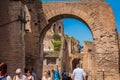 Tourists walking by the archway at Via Nova on the ancient Roman Forum in Rome