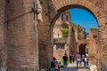 Tourists walking by the archway at Via Nova on the ancient Roman Forum in Rome