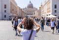 ROME, ITALY - APRIL 27, 2019: Young woman photographs the Saint Peter`s Basilica, Rome, Italy. Royalty Free Stock Photo