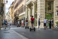 People on Segways ride along a street in the center of Rome