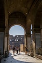 People sightsee and go through an ancient arch