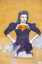 Poster and additional painting of super woman at a house wall in roman quarter Trastevere