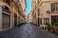 Rome, Italy - August 22, 2018: Typical old Roman narrow street. Lovely plants near old walls.
