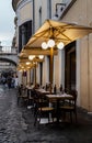 Rome, Italy - August 20, 2018: Typical old Roman narrow street. Lovely sidewalk cafÃÂ© with empty tables, umbrellas and lanterns.