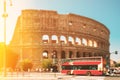 Rome, Italy. Colosseum. Glare Light On Red Hop On Hop Off Touristic Bus For Sightseeing Near Flavian Amphitheatre