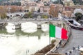 Rome, Italy - December 17, 2019: Rome skyline and river Tibre as seen from Castel Sant`Angelo with Italian flag