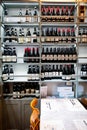 Table in wine shop with large numbers of bottles on shelf