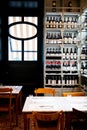 Table in wine shop with large numbers of bottles on shelf