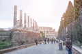 Rome, Italy - February 23, 2019: View of Colosseum from Via dei Fori Imperiali. People walking down the street to the