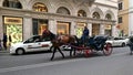 A house carrying an empty carriage with a coachman driving on a busy street in downtown Rome before the pandemic