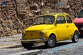 Rome, Italy - June 30, 2019: Cute little yellow retro Fiat parked on street. Italian vintage car