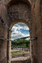 Rome, Italy - 23 June 2018: Ruins of the roman forum viewed through the gated arch of the passage at the entrance of the Roman Royalty Free Stock Photo