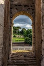 Rome, Italy - 23 June 2018: Ruins of the roman forum viewed through the gated arch of the passage at the entrance of the Roman Royalty Free Stock Photo