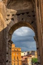 Rome, Italy - 23 June 2018: Ruins of the roman forum viewed through the gated arch of the passage at the entrance of the Roman Royalty Free Stock Photo