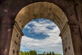 Rome, Italy - 23 June 2018: Ruins of the roman forum viewed through the gated arch of the passage at the entrance of the Roman Royalty Free Stock Photo