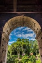 Rome, Italy - 23 June 2018: Ruins of the roman forum viewed through the gated arch of the passage at the entrance of the Roman Royalty Free Stock Photo