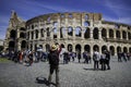 ROME-ITALY-MAY-19-2019: Tourists enjoy a sunny day as take a picture by smartphone to visit de fabulous Colosseum