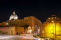 City life in central Rome and view of the Basilica di San Pietro dome. Night scene Royalty Free Stock Photo