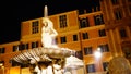 Night long exposition of the triton of the homonymous fountain and buildings in the background