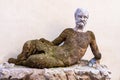 Outdoor sculpture of mossy overgrown man lying on the stone above the fountain in the front entrance of Canova Tadolini Museum in Royalty Free Stock Photo