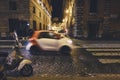 Vespa bike and passing cars in Rome