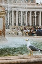 Rome, Italy October 2019: Fountain in Piazza San Pietro in Vatican against The Papal Basilica of Saint Peter, cloudy day Royalty Free Stock Photo