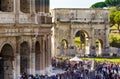 Large crowd of people staying in line at Colosseum near Arch of Constantine