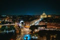 Rome, Italy, panorama of historical center at night. Vatican dome of Saint Peter Basilica, bridge over Tiber river and