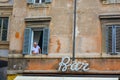 Italian pensioner looking outside from the window. Very old building in Rome, capital of Italy, sign for Bar cafe downstairs Royalty Free Stock Photo