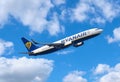 Ryanair plane flying on a beautiful blue sky with scattered clouds