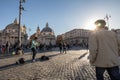 11/09/2018 - Rome, Italy: Sunday afternoon Violin Street musician playin at sunset in piazza del popolo full of tourists walking